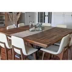 a wooden table with white chairs around it