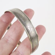 A fine diamond engraved pattern flows around this vintage 1930s era Art Deco sterling silver bangle bracelet. The bracelet has an authentic aged look, perfect for stacking with other bracelets. The 7/16 inch wide bracelet has a round slightly domed shape with slight irregularities to its roundness. The inside is hallmarked, "Sterling" with no other identifying marks. The total inner circumference measures approx. 7 1/4 inches. For its 1930s age this piece is in very good condition. It has expect Silver Bangle Bracelet, 1930s Art, Sterling Silver Bangle Bracelets, Sterling Silver Bangle, Wide Bracelet, 1930s Art Deco, Sterling Silver Bangles, Silver Bangle, Machine Tools