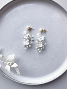 Are you looking for floral bridal earrings? You'll find them here! These earrings made of white ceramic flowers are a real eye-catcher and perfect as bridal jewelry! Stud earrings made of 316L stainless steel jewelry wire Pearls and fine ceramic flowers For more jewelry inspo, check out our shop! You can also find matching hairpins here 🤍 💫 White Dangle Earrings For Wedding Gift, White Dangle Jewelry For Bridal Shower, White Wedding Jewelry With Flower Decoration, White Flower Decoration Wedding Jewelry, Delicate White Handmade Flower Earrings, Delicate White Jewelry With Matching Earrings, White Drop Earrings For Bridal Shower, White Dangle Flower Earrings With 3d Flowers, White Flower Jewelry With Handmade Flowers