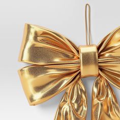 a gold bow ornament on a white background