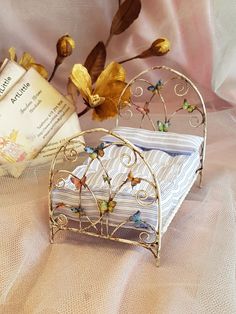 there is a small metal bed with butterflies on it and a book next to it