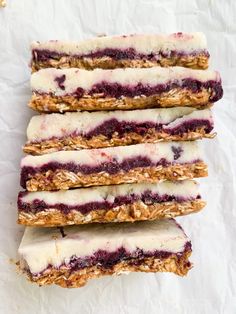 four granola bars stacked on top of each other with blueberries and yogurt