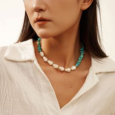 Step into the world of bohemian elegance with our Baroque Pearl Turquoise Necklace , a masterpiece that seamlessly blends the raw beauty of natural stones with the sophistication of pearls. This striking necklace is crafted from high-quality materials, featuring a dynamic combination of turquoise chips and lustrous pearls. The turquoise stones, with their rich blue-green hues and unique veining, offer a vibrant contrast to the smooth, iridescent pearls, each one distinct in its organic shape and glossy finish.   Let this necklace be the centerpiece of your jewelry collection, a symbol of your unique taste and sophisticated charm. DETAILS Plating: 14K Gold Materials: 925 Sterling Silver , Turquoise, Baroque Shell Pearl Measurements: Length: 15.74"(40cm) + Extender: 1.97"(5.0cm) Weight: 32.1 Chip Stone Jewelry, Turquoise Chip Necklace, Iridescent Pearl, Layered Chokers, Pearl Choker Necklace, Pearl Choker, Green Turquoise, Baroque Pearls, Natural Pearls