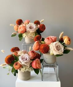 three vases with flowers on top of each other