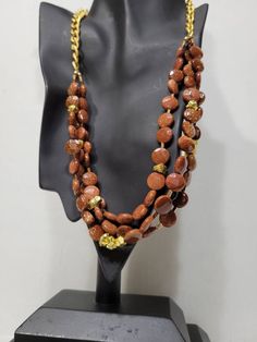 "Multistrand goldstone glass bead and gold nugget layered necklace. Three strands of glass beads (faceted and smooth) with a gold finish curb link chain tying them together. Color is a gold dusted rich dark copper. Goldstone is a type of glittering glass made in a low-oxygen reducing atmosphere. ●Length: 22\" ●Linda's Designers Group features a collection of unique china, luxury estate sale handbags, vintage statement jewelry and handmade 'one of a kind' jewelry. We will gladly provide additiona Handmade Adjustable Gold Layered Necklace, Gold Necklaces With Faceted Beads For Jewelry Making, Handmade Double Strand Gold Long Necklace, Adjustable Handmade Gold Layered Necklace, Gold Beaded Necklaces With Natural Stones And Czech Glass, Handmade Double Strand Long Gold Necklace, Gold Beaded Necklace With Gemstone For Costume Jewelry, Gold Costume Jewelry Necklace With Gemstone Beads, Gold Costume Jewelry Beaded Necklaces With Gemstones