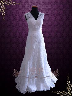 a white wedding dress on display in front of a purple background with gold trimmings