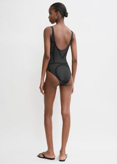 This swimsuit is printed with TOTEME's signature monogram pattern in two shades of black. It is made in Portugal from four way-stretch, recycled-polyamide jersey which protects against sun rays, and is shaped to a classic silhouette with a deep U-back. Pack it with the Monogram jacquard beach towel for your next vacation. Second-skin Black Swimwear For The Beach, Second-skin Fit Black Swimwear For Beach, Compressive Polyamide Swimwear For Summer, Black Stretch Bodysuit In Polyamide, Black Stretch Polyamide Bodysuit, Compressive Black Nylon Bodysuit, Black Compressive Nylon Bodysuit, Black Compressive Swimwear With Lined Body, Compressive Lined Swimwear