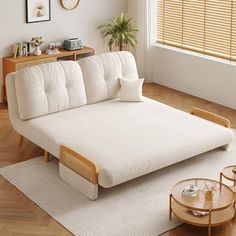 a living room with a white couch and coffee table on top of the rugs