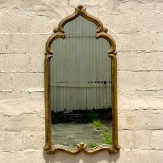 a mirror on the side of a brick wall with a white building in the background