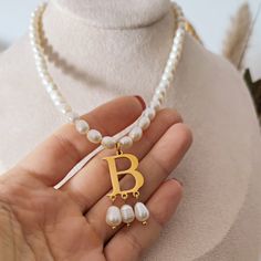 "This freshwater pearls and initial necklace is the perfect jewel to feel like a queen! Handcrafted with the utmost of care, this choker is inspired by the famous \"B\" initial necklace worn by Anne Boleyn in all her official portraits. The choker is made of real freshwater pearls with an irregular, oval shape and a gorgeous \"B\" initial at the center, made of 14k gold plated stainless steel, with three dangling drop pearls. Length of the choker is 37cm, with an addition of 4cm extender chain. Elegant Pearl Jewelry With Letter Beads, Elegant Gold Pearl Necklace With Letter Beads, Gold Pearl Necklace With Letter Beads, White Pearl Necklace With Initial Pendant, B Initial Necklace, Daylight Ring, B Necklace, B Initial, Pearls Choker