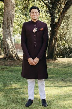 DETAILS Traditional Quaid tailored sherwani with a front placket and fitted collar. Paired with a traditional kurta and Aligarh cut pajama. COLOR Maroon SIZE Custom Order - A measurement guide will be sent upon order. Model is 6'1 MATERIAL Sherwani - WoolKurta - CottonPajama - Cotton PRODUCT CODE 300000-24-05 PRODUCT OF PAKISTAN GARMENT CARE Handle With Care Professionally Dry Clean Only Fitted Nehru Jacket With Naqshi In Straight Kurta Style, Fitted Nehru Jacket With Naqshi Straight Kurta, Traditional Tailored Bandhgala With Resham Embroidery, Tailored Kurta For Festive Occasions, Classic Fitted Traditional Wear For Ceremonies, Fitted Kurta With Zari Work And Stand Collar, Fitted Ceremonial Kurta With Stand Collar, Tailored Festive Sherwani For Eid, Traditional Tailored Kurta For Eid