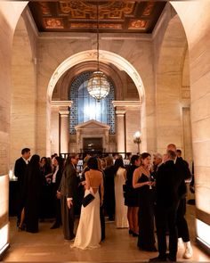 a group of people standing around each other in a room with stone walls and ceilings