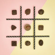 chocolate candies arranged in squares on a pink and yellow background