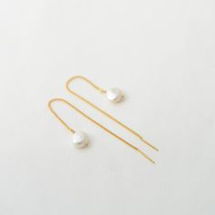 "Dainty Freshwater pearl threader earrings come in two sizes. They are lightweight and easy to put on which makes them suitable for everyday use. They would make the perfect gift idea for bridesmaids on your special day. D E T A I L S - Gorgeous organically shaped freshwater pearls - Lightweight and effortless. Suitable for everyday use - Easy to put on through wire bar ends - A freshwater pearl hanging from a delicate nickel-free chain - Each pearl is unique and irregular in shape by nature and Adjustable Dainty Pearl Earrings, Pearl Dangle Threader Earrings With Pearl Chain, Drop Threader Earrings With Pearl Chain For Gift, Pearl Chain Drop Threader Earrings As Gift, Dainty Threader Earrings With Pearl Drop Gift, Gold Pearl Threader Earrings Gift, Minimalist Pearl Earrings With Adjustable Chain, Dangle Pearl Drop Threader Earrings As Gift, Adjustable Dangle Pearl Earrings With Pearl Chain