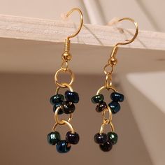 two pairs of earrings hanging from a hook