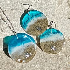 two blue and white glass pendants on a silver chain with diamonds hanging from them