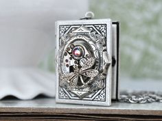 Vintage jeweled watch movement sets on custom silver plated over brass locket and it hangs on 18 inch surgical steel chain with lobster clasp. Measurement, Locket is about 1.4 inch (35mm) in length and 1.1 inch (27mm) in width on 18 inch chain. If you have a preferred length for the chain, please let me know in message to seller box and I will adjust it before shipping. Antique Silver Stainless Steel Jewelry For Gift, Steampunk Silver Pendant Necklace, Silver Steampunk Pendant Necklace, Antique Silver Jewelry With Vintage Charm As Gift, Vintage Silver Locket Necklace With Lobster Clasp, Silver Steampunk Metal Jewelry, Steampunk Silver Jewelry For Weddings, Unique Antique Silver Jewelry, Unique Silver Jewelry With Vintage Charm