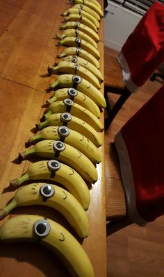 a long row of bananas with faces drawn on them and santa's hat in the background