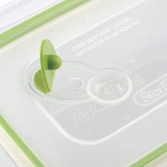 a close up of a plastic container with a green object sticking out of the lid