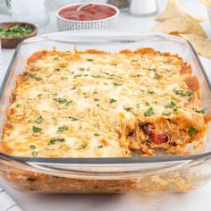 a casserole dish with meat and cheese in it on a white tablecloth