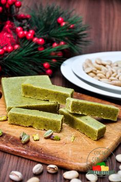 pieces of matcha on a wooden cutting board with nuts and holly wreath in the background