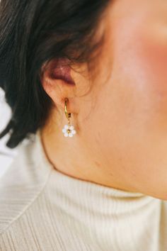 Spruce up your outfit with these playful Dropping Daisies Earrings! These gold hoops feature a charming white beaded flower design with a gold center, adding a touch of whimsy to your look. Perfect for adding a fun and unique twist to any outfit. Gold earrings White beaded flower design with gold center Huggie/hoop earrings with dropped flowers