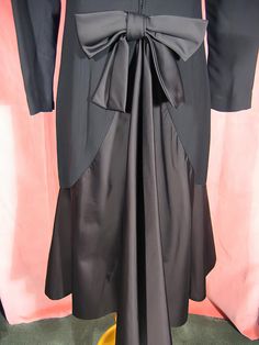 "Dramatic 70's cocktail dress in black crepe and satin by Estevez, who was the youngest designer to win the Coty award. Beautifully made, it's completely lined, and about a size 6. It measures approx. 14\" across slightly padded shoulders, up to 37\" bust, 20 1/2\" outside sleeve length, 28\" waist, 38\" hips, and 43\" overall length. It's in excellent, like new, condition. See my entire shop collection here https://www.etsy.com/shop/RobinClaytonVintage" Elegant Black Dress With Satin Trim, Silk Party Dress With Satin Trim, Evening Dress With Satin Trim, Evening Satin Dress With Satin Trim, Chic Party Dresses With Satin Trim, Elegant Party Dresses With Satin Trim, Formal Satin Dress With Satin Trim, Chic Evening Dress With Satin Trim, Chic Evening Dresses With Satin Trim