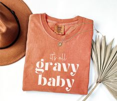 Add some humor to your holiday with our "It's All Gravy Baby" Comfort Colors shirt! This funny Thanksgiving tee is perfect for those who love a retro vibe and a playful twist on Turkey Day. Whether you're wearing it to a family gathering or just enjoying the fall season, this gravy Thanksgiving shirt is sure to be a hit. EACH ITEM SOLD SEPARATELY See photos and please read the following for more info: STYLE + SIZING ★ UNISEX Comfort Colors 1717 Garment-Dyed T-shirt ★ Colors may vary (see photo c Gravy Thanksgiving, Retro Thanksgiving, Thanksgiving Tee, Photo C, Turkey Day, Thanksgiving Shirt, Comfort Colors Shirt, Funny Thanksgiving, Baby Comforter