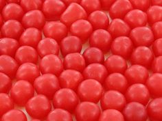 red candy candies are arranged on a white surface