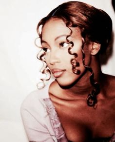 a woman with curly hair is posing for the camera