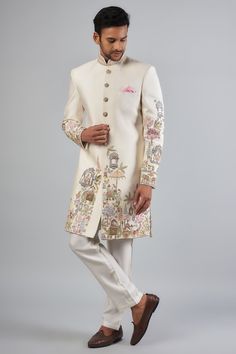 Featuring an ivory sherwani in Malai satin base with embroidered resham thread work. It is paired with heavy tensile dyed cotton pants. Perfect for a wedding or engagement ceremony.  (you can make simple kurta also for occation) Inclue:- (i) kurta (top) with inner cotton layer (ii) pant/chudidar white color (bottom) Men Sherwani Designs Style, Cotton Bandhgala With Resham Embroidery In Traditional Drape, Designer Sherwani With Embroidered Border And Traditional Drape, Bollywood Cotton Bandhgala With Floral Embroidery, Diwali Sherwani With Floral Embroidery In Raw Silk, White Sherwani With Floral Embroidery For Diwali, Traditional Cotton Bandhgala With Floral Embroidery, Fitted Cotton Sherwani With Floral Embroidery, Embroidered Off White Cotton Sherwani