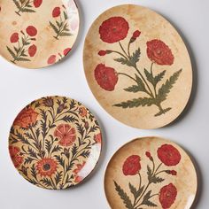 three plates with red flowers painted on them