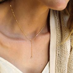 "Our lariat necklace is perfect minimalist jewelry. This dainty necklace is perfect with your favorite tee or your little black dress. A tiny cubic zircon drop adorns a 14kt gold filled chain.  D E T A I L S *Tiny cubic zircon drop - gold over sterling silver  *2 inch drop  *Dainty link chain *100% 14kt gold dainty link chain  LENGTH *The standard length is normally 18\". *Model is wearing a 16\" in Photos. HOW TO PERSONALIZE *Select your choices from the drop down menu to create your custom design. ∙ EXTRA LOVE ∙ Handcrafted just for you in sunny Arizona by a team of talented women. All of our jewelry comes gift packaged! We are happy to leave a note if this is a special gift, just let us know in the message box at checkout. PRODUCTION ∙ TIMES All items are made to order. Please check the Necklace Minimalist Jewelry, Dainty Necklaces, Large Gift Boxes, Gold Filled Necklace, Necklace Minimalist, Message Box, Necklace Dainty, Necklaces For Women, Lariat Necklace