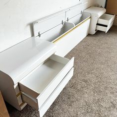 a white bed with two drawers underneath it