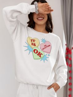 ✨This cute Valentine's Day candy “It Is OK to Stutter” Gildan 18000 unisex sweatshirt is an ideal gift for yourself and friends or relatives who stutter and their stuttering allies. It’s the perfect way to self-advertise that you stutter and to advocate for people who stutter everywhere with a reminder that they're not alone. A portion of the proceeds will go towards National Stuttering Association (NSA) support groups - thanks for supporting the Normalize Stuttering movement! ✨Ideal for any sit White Crew Neck Sweatshirt With Heart Graphic, Trendy Valentine's Day Crew Neck Sweatshirt, Valentine's Day White Crew Neck Sweatshirt, Cute White Slogan Sweatshirt, Casual Heart Graphic Sweatshirt Gift, White Crew Neck Sweatshirt For Valentine's Day, Valentine's Day White Casual Sweatshirt, Cute White Sweatshirt With Slogan, White Casual Sweatshirt For Valentine's Day