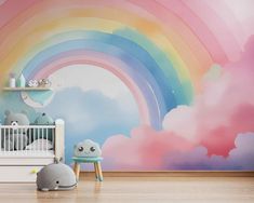 a baby's room decorated in pastel colors with a rainbow painted on the wall