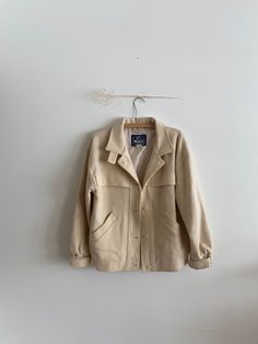 "Vintage Cream Wool Jacket The Woolrich Woman 100% Pure Wool Velcro Sleeve Cuffs Small holes, vintage wear throughout *see pictures 26\" Length 21\" PtP 21\" Sleeve Length" Vintage Fall Blazer With Button Cuffs, Retro Beige Blazer For Fall, Vintage Button-up Outerwear For Fall, Vintage Beige Utility Jacket For Spring, Retro Cream Outerwear For Fall, Vintage Single Breasted Blazer For Fall, Retro Beige Fall Blazer, Vintage Button-up Fall Outerwear, Vintage Utility Jacket With Lapel Collar For Spring