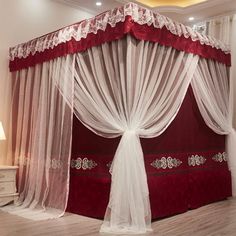 a red and white canopy bed with sheer curtains