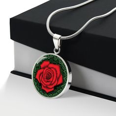 Red Rose Circle Pendant Necklace The Red Rose Circle Pendant Necklace is a beautiful and meaningful gift that can be given to that special person in your life. Whether it's your significant other, your best friend, or a family member, expressing love and support is always important, especially when they're going through a tough time. The red rose pendant is a symbol of many things such as romance, love, beauty, passion, and courage. It's a powerful reminder that love can conquer all, and that th Rose Red Jewelry For Valentine's Day Anniversary, Red Jewelry With Gift Box, Rose Jewelry With Roses Detail As Gift For Her, Red Jewelry Gift Box Included, Red Jewelry For Valentine's Day Gift, Rose-themed Jewelry As Gift For Her, Rose Design Round Pendant Necklace As Gift, Gift Red Rose Necklaces, Rose Sterling Silver Necklace For Gift