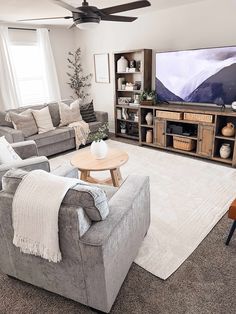 a living room filled with furniture and a flat screen tv sitting on top of a wooden stand