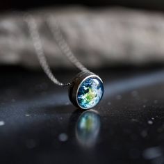 a necklace with the earth on it sitting on a table