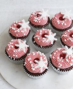 cupcakes with pink frosting and white sprinkles on a plate