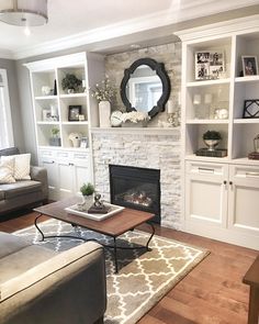 a living room filled with furniture and a fire place in front of a white fireplace