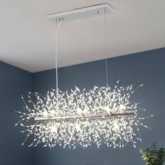 a modern chandelier with white flowers hanging from the ceiling