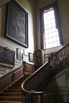 a staircase with pictures on the wall and paintings on the walls