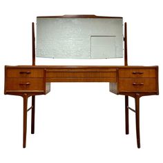 a wooden desk with two drawers and a large mirror on it's top shelf