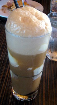 a tall glass filled with liquid sitting on top of a table