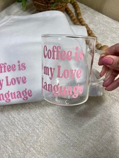 a person holding a coffee mug with pink lettering on it and another cup that says coffee is my love language