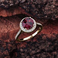 This garnet engagement ring in 14K white gold features a round garnet center stone that is complemented by brilliant white, sparkly diamond side stones. Garnet Engagement Details: 100% Handmade in the USA Center Stone - Garnet (2.00 carat AAA / VS) Metal - 100% Solid 14K (In Rose, Yellow, or White) Diamond Side Stones: Carat Weight - 0.33 carat total weight Shape - Round Cut Diamonds Color - G - H Clarity - SI1 Finger Size: We can make this setting in any finger size you need! Contact us if you Fine Jewelry Round Cluster Ring With Garnet, Fine Jewelry Garnet Cluster Ring, Elegant Garnet Birthstone Ring With Center Stone, Garnet Center Stone Birthstone Ring, Garnet Gemstone Cluster Ring, Diamond Ring With Center Stone And Lab-created Ruby, Round Diamond Ring With Center Lab-created Ruby, Elegant Lab-created Ruby Birthstone Ring With Center Stone, Classic Diamond Ring With Halo Setting And Lab-created Ruby