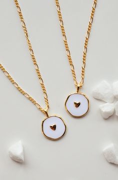 This is a new favorite minimal charm necklace. It's SO pretty. White charm with a gold heart in the middle, and it's hanging from our logan chain. Layer this up with a Luna necklace and you've got a really beautiful stack. Gold-filled is the closest alternative to solid gold. Gold filled jewelry has a thick layer of solid gold bonded onto the base layer, usually brass or sterling silver. Compared to gold plated which uses a process of electroplating that quickly dips your jewelry in gold, result Minimalist Everyday Charm Necklace With Heart Charm, Minimalist Everyday Necklace With Heart Charm, Minimalist Everyday Charm Necklace With Heart, Dainty Everyday Heart Charm Necklace, Dainty Heart Charm Necklace For Best Friend Gift, Dainty Heart Charm Necklace For Best Friend, Minimalist Jewelry With Heart Charm Round Pendant, Heart Charm Jewelry For Best Friend Gift, Minimalist Jewelry With Heart Charm On Round Pendant